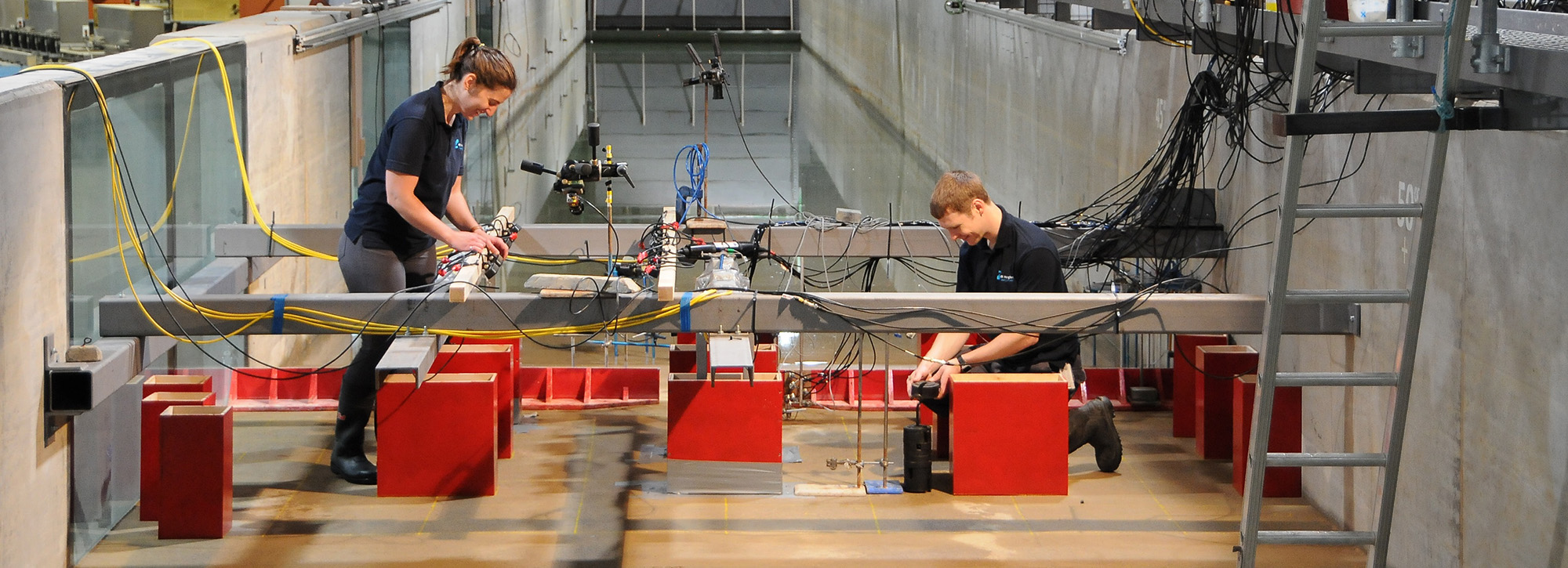 View of two people working in our tsunami simulator in our modelling facilities