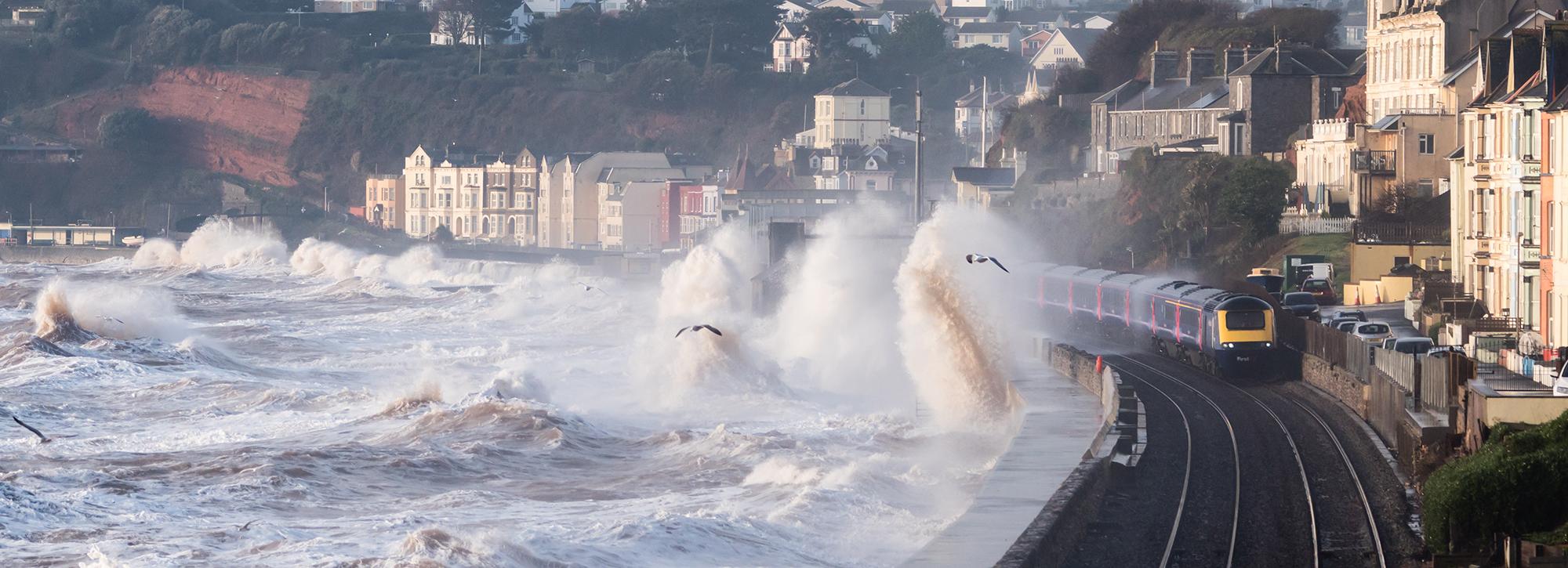 Panoramic view of overtopping on coastal areas with house and train railway tracks