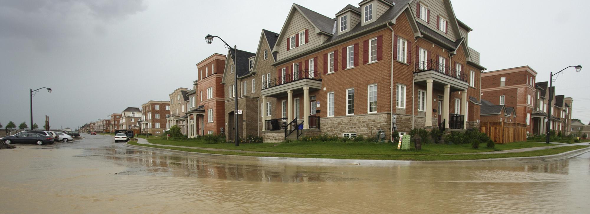 New houses development surrounded by brown water due to flooding