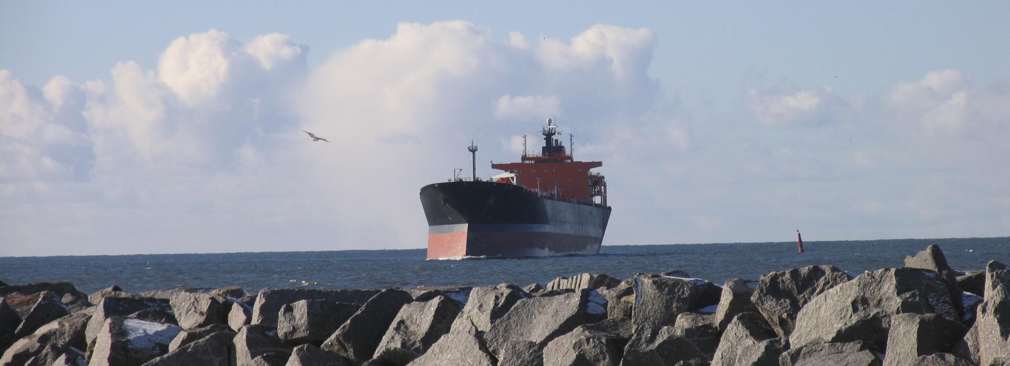 A large tanker at a breakwater made with armourstones