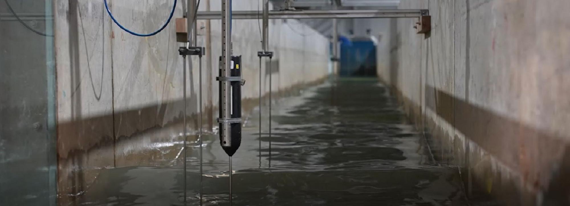 View of a flume physical model with water and instrumentation