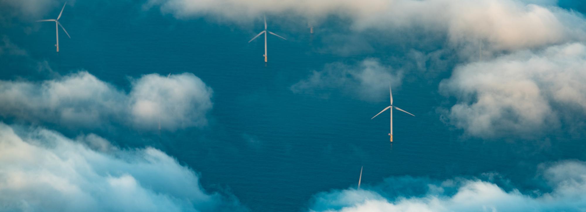 Aerial view of wind farm in sea with white clouds