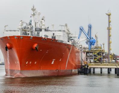View of a red LNG tanker moored at a port