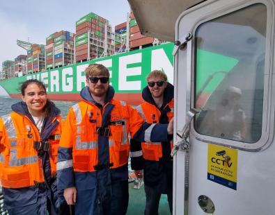 Three graduates with life safety jackets on boats on Port of Felixstowe. 