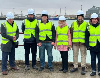 HR Wallingford and World Bank staff in high visibility jackets standing for a picture in Port of Aktau on Caspian sea