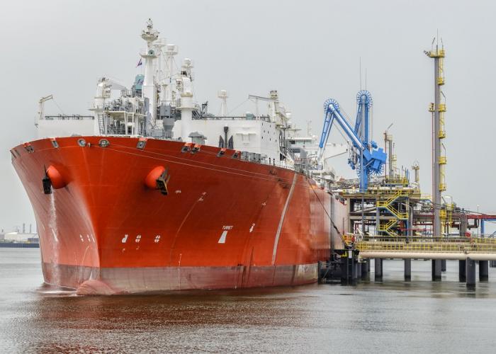 View of a red LNG tanker moored at a port