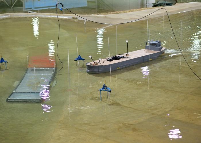 Photo of physical model of Oosterweel Scheldt tunnel with a model boat