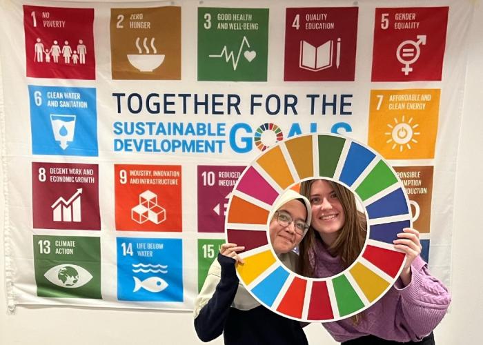 HR Wallingford young members of staff pausing in front of UN Sustainable goals banner