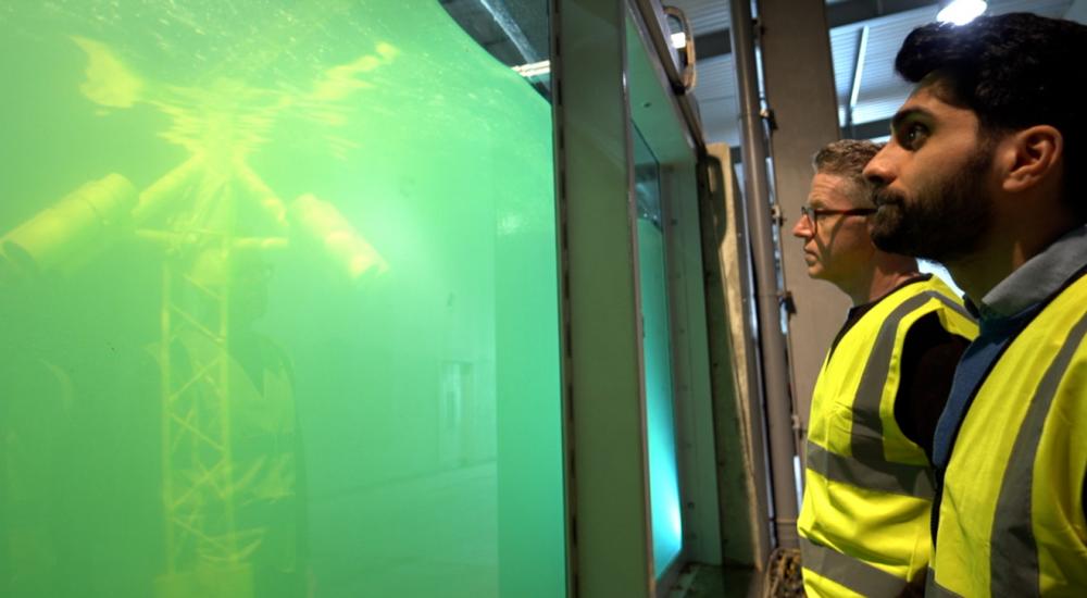 Two HR Wallingford staff looking at the Fast Flow Facility with Stinger Keel model
