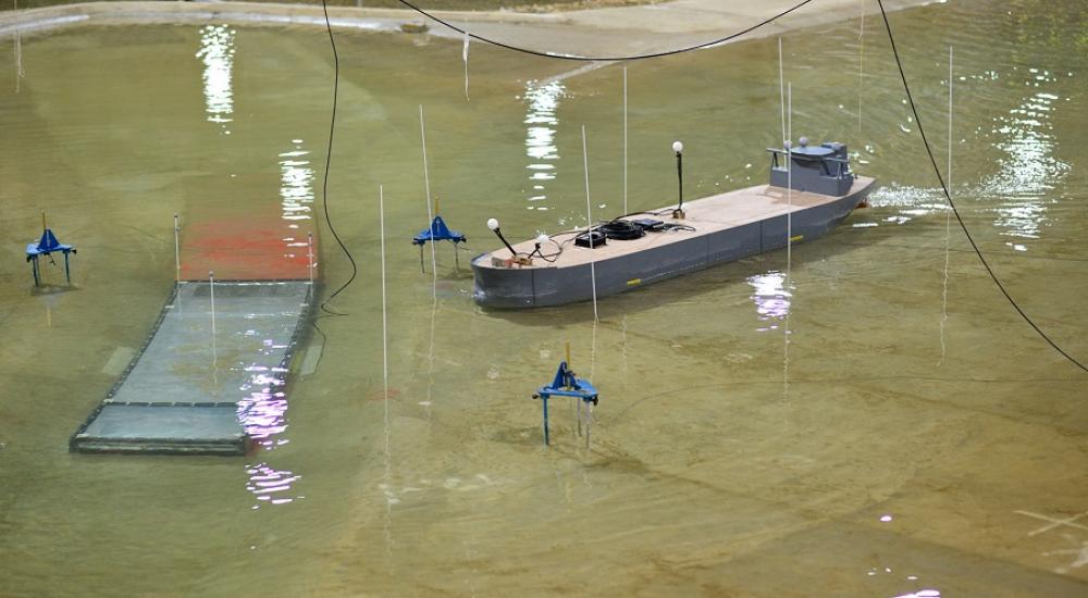 Photo of physical model of Oosterweel Scheldt tunnel with a model boat