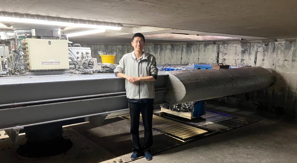 Picture of researcher Diamind Xu in front of physical model at Cambridge Lab