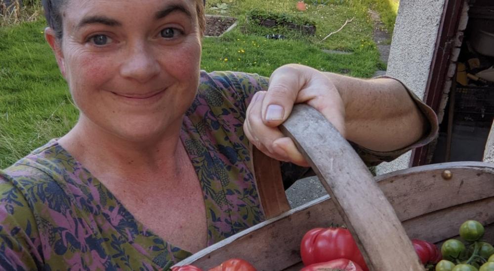 Picture of female scientist, Kerry Marten, with her crop of tomatoes in a basket