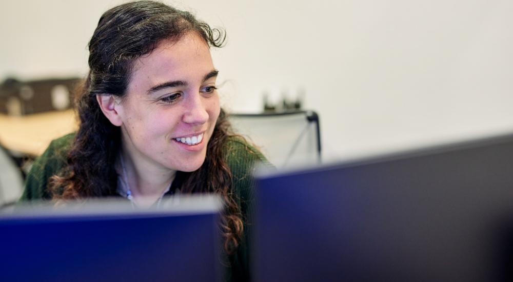 View of female ship engineer behind computer screens