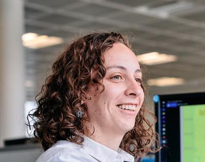 Engineer Juliette Parisi at her desk with computer screen at the back