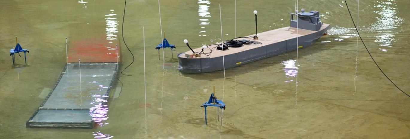 Photo of physical model of Oosterweel Scheldt tunnel with a model boat