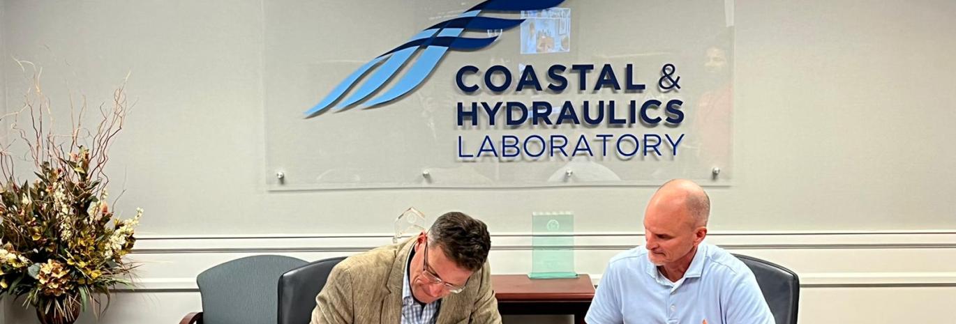 Picture of HR Wallingford CEO signing agreement with USACE