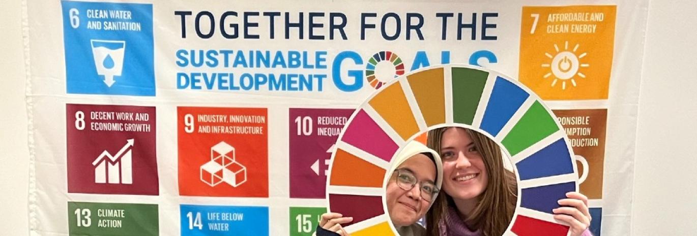 HR Wallingford young members of staff pausing in front of UN Sustainable goals banner
