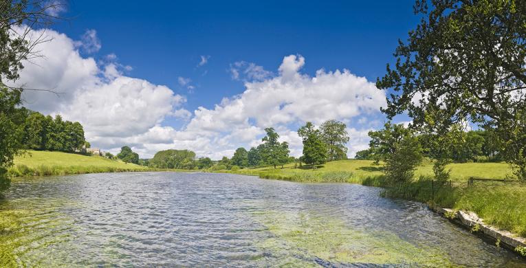 View of wide freshwater river with green river banks